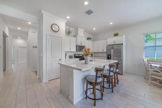 a kitchen with kitchen island granite countertop lots of counter top space and stainless steel appliances