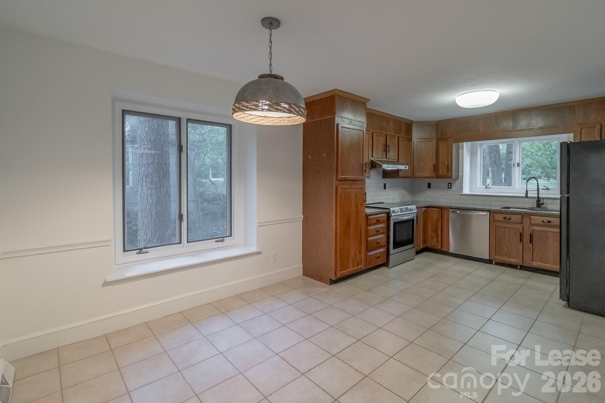 3917 Singletree Road Mint Hill, NC 28227 - Photo 26 of 47 a kitchen with stainless steel appliances a sink a stove a refrigerator cabinets and a window