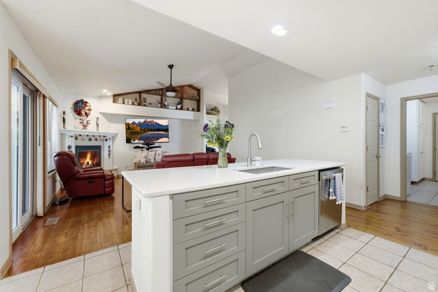5196 Rodeo Circle Oakley, UT 84055 - Photo 14 of 57 Kitchen island featuring a single-basin sink with a gooseneck faucet, light gray cabinetry, and a white countertop