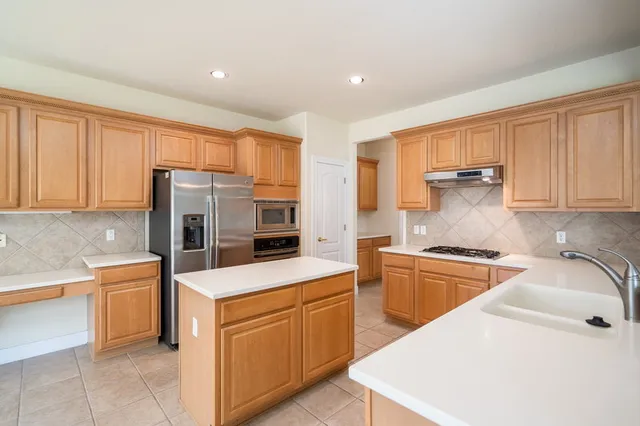 a kitchen with a table chairs refrigerator and cabinets