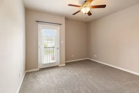 an empty room with windows and ceiling fan