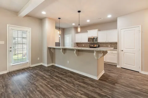 a kitchen with stainless steel appliances granite countertop a stove a sink and a refrigerator