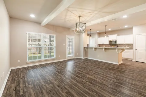 a view of a kitchen with a fridge wooden floor and a kitchen