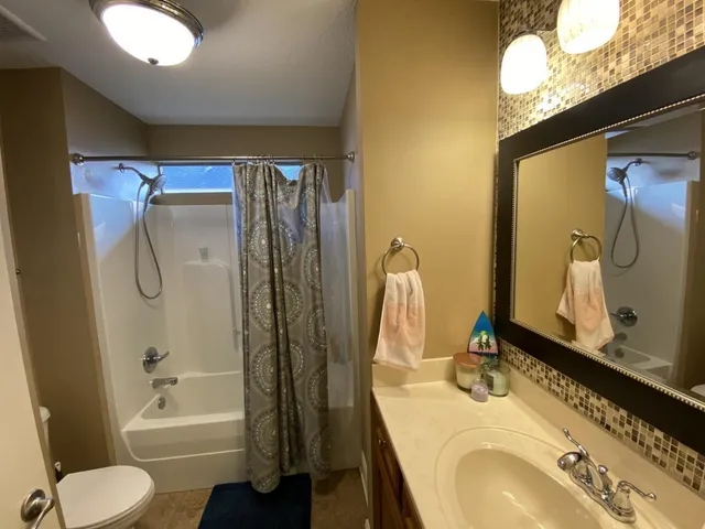 a bathroom with a granite countertop sink toilet and shower