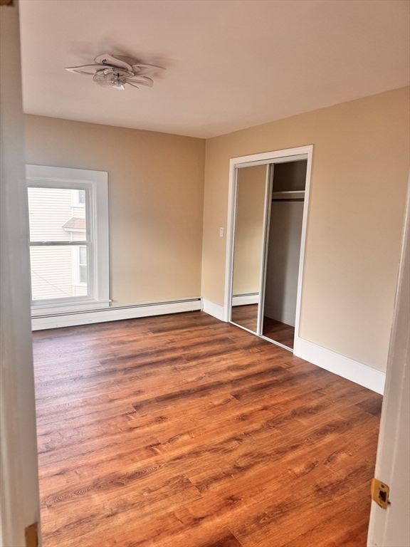 66 Taylor Street, Unit 2 Holyoke, MA 01040 - Photo 19 of 29 a view of empty room with wooden floor and fan