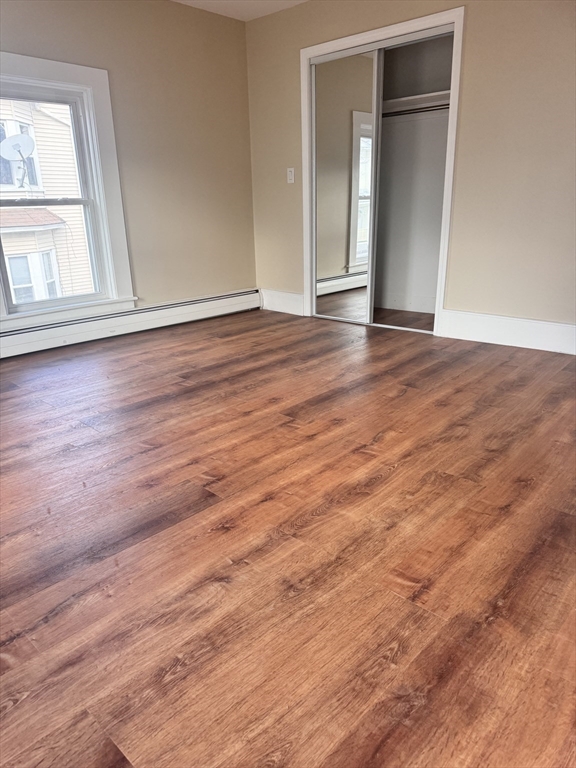 66 Taylor Street, Unit 2 Holyoke, MA 01040 - Photo 20 of 29 an empty room with wooden floor and windows