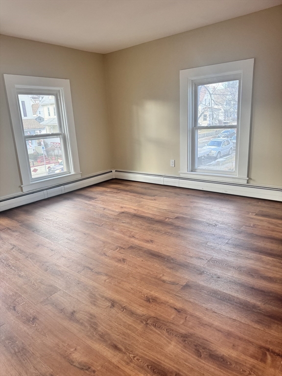 66 Taylor Street, Unit 2 Holyoke, MA 01040 - Photo 21 of 29 a view of an empty room with wooden floor and a window