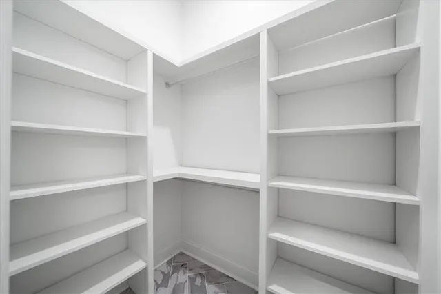 a view of walk in closet with empty racks