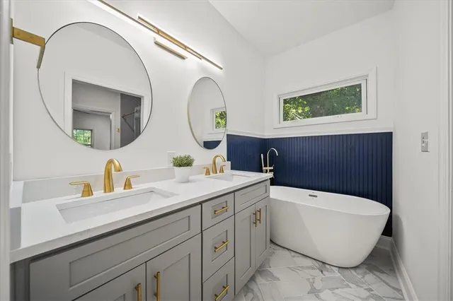a bathroom with a bathtub sink and mirror