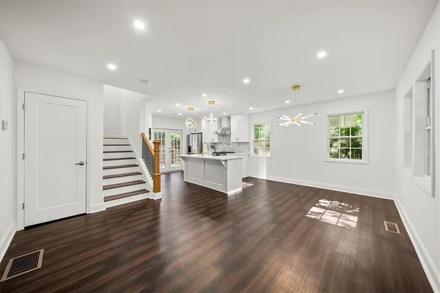 a view of entryway and kitchen with wooden floor