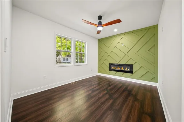 a view of an empty room with a window and wooden floor