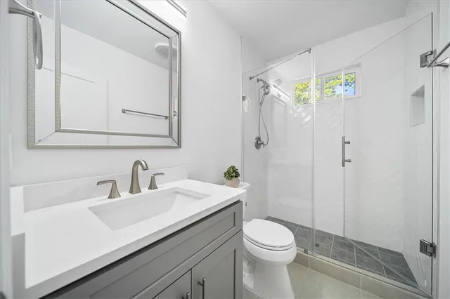 a bathroom with a sink a toilet and shower