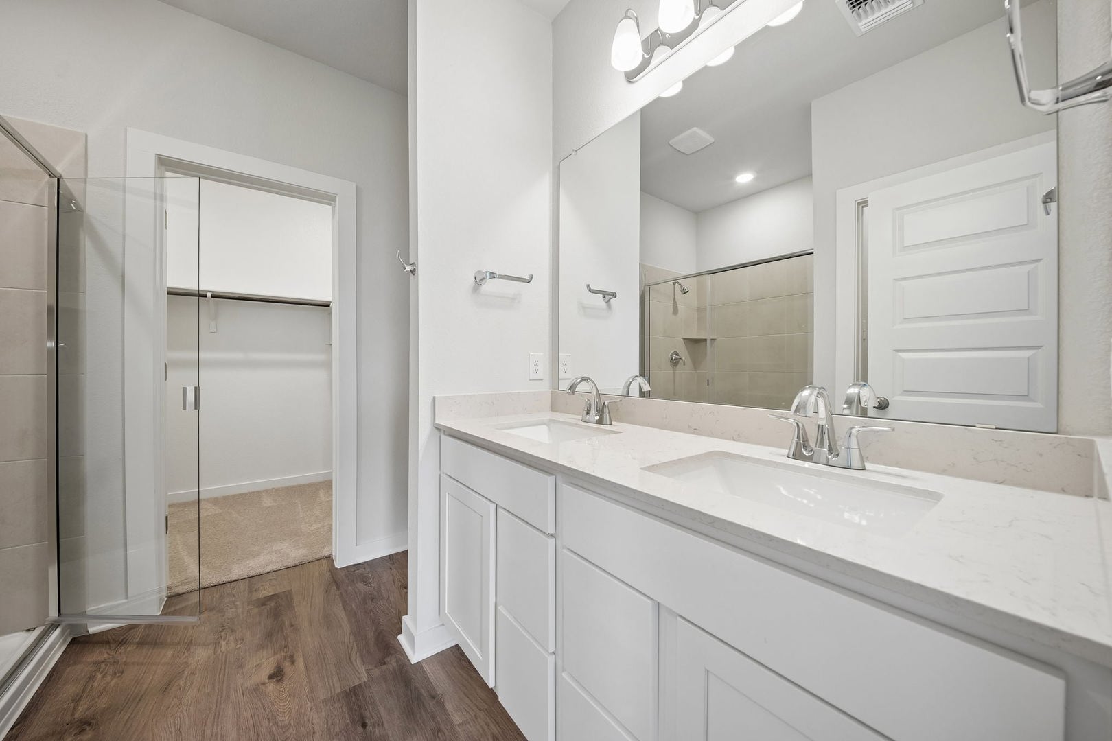 113 Two Bits Lane Elgin, TX 78621 - Photo 20 of 23 Dual vanities with stone counters and modern fixtures enhance this well-appointed bathroom, featuring a spacious shower and direct access to a walk-in closet.