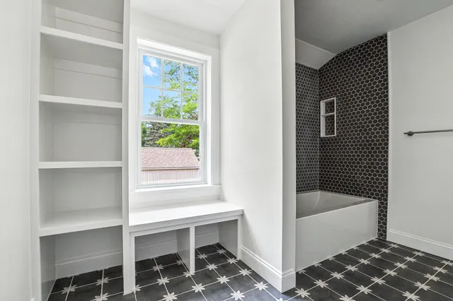 a bathroom with a bathtub and next to a window