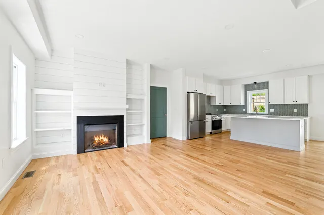 a view of kitchen with kitchen island wooden floor and refrigerator