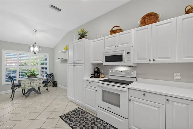 a kitchen with stainless steel appliances white cabinets and a stove top oven