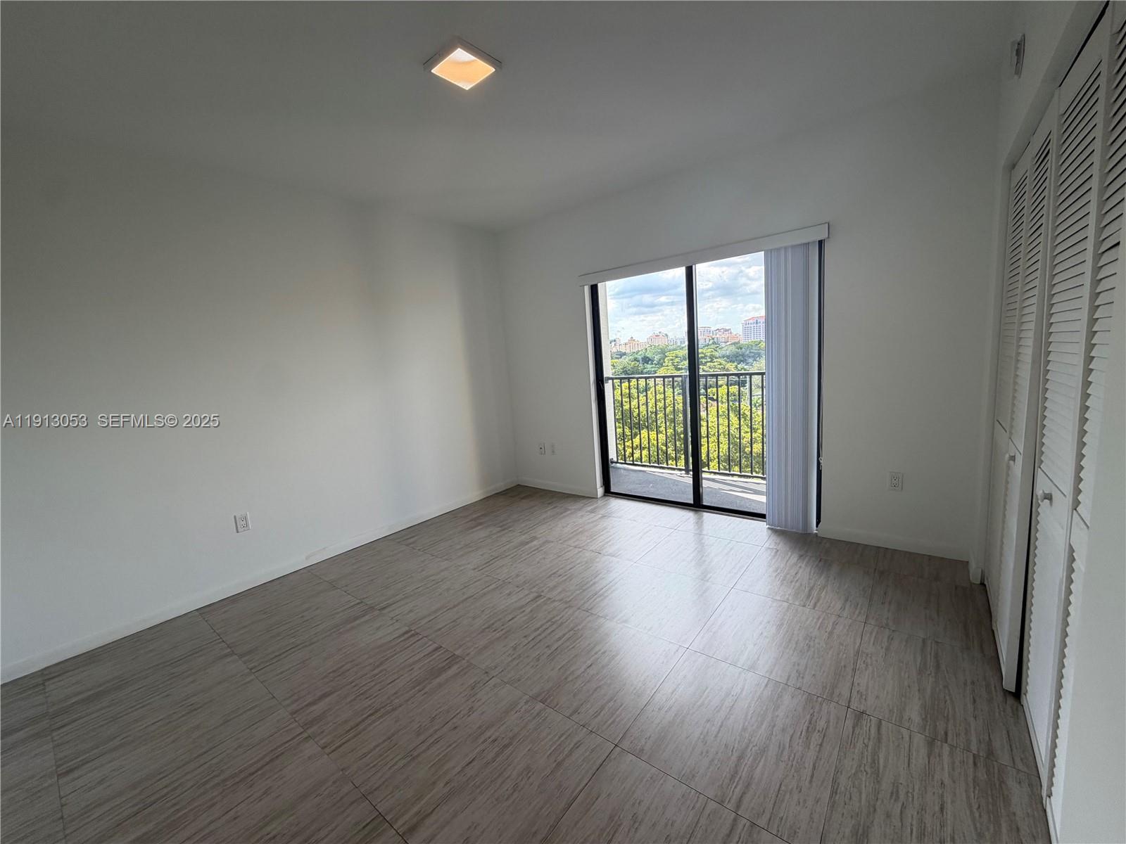 1801 Southwest 32nd Avenue, Unit 504 Miami, FL 33145 - Photo 12 of 14 a view of an empty room with wooden floor and a window