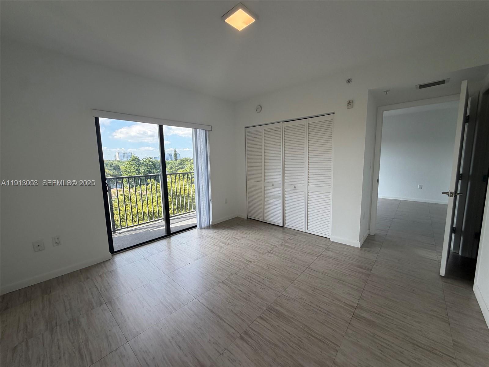 1801 Southwest 32nd Avenue, Unit 504 Miami, FL 33145 - Photo 10 of 14 an empty room with wooden floor and windows