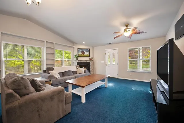 a living room with furniture a flat screen tv and a large window