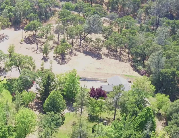 an aerial view of a house with a yard and lake view