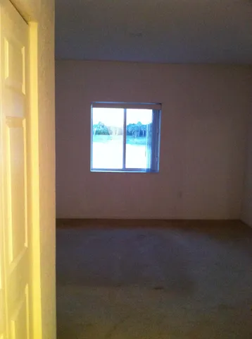 a view of a livingroom with an empty space and a window