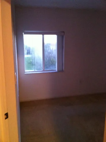 a view of a room that has wooden floor and a window