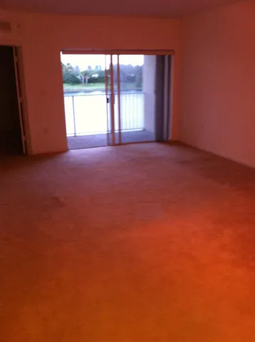 a view of an empty room with a fireplace and a window