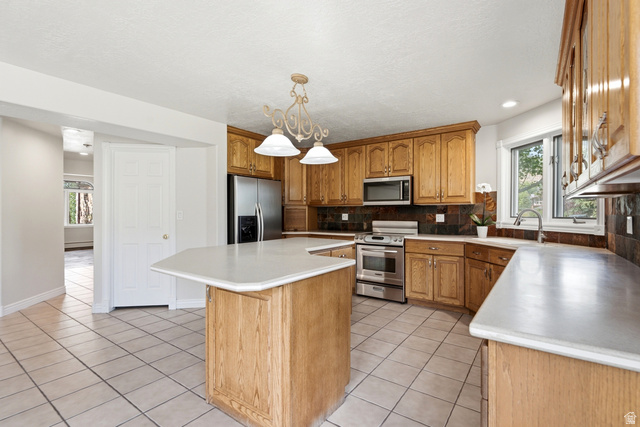 3535 Homestead Road Park City, UT 84098 - Photo 16 of 81 Kitchen featuring a central island with countertop, light wood-finish cabinetry, tile flooring, stainless steel appliances, and a window above the sink