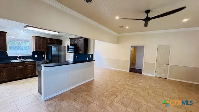 a large kitchen with stainless steel appliances kitchen island granite countertop a refrigerator and a stove top oven
