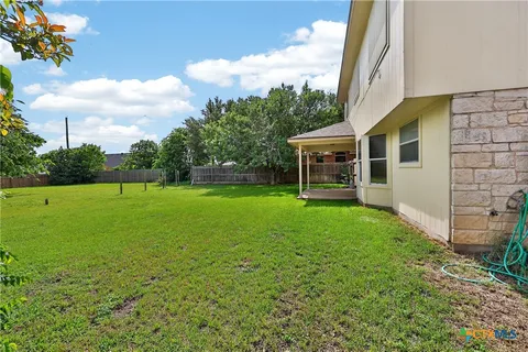 a view of a house with backyard and a tree