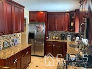 344 Union Avenue Middlesex, NJ 08846 - Photo 6 of 22 a kitchen with stainless steel appliances granite countertop a refrigerator a stove and a sink with wooden cabinets