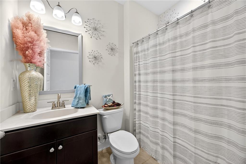 419 Beachview Road Hampton, GA 30228 - Photo 14 of 32 a bathroom with a sink a toilet and shower curtain