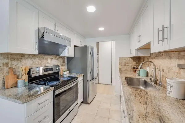 a kitchen with stainless steel appliances granite countertop a sink stove and refrigerator