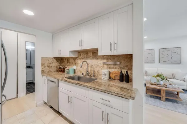a kitchen with stainless steel appliances granite countertop a sink refrigerator and cabinets