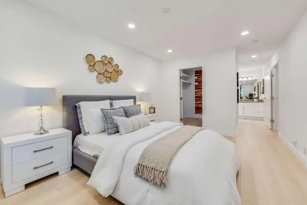 a bedroom with a bed and a painting on the wall