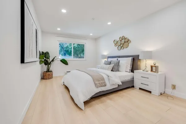 a bedroom with a bed and a potted plant