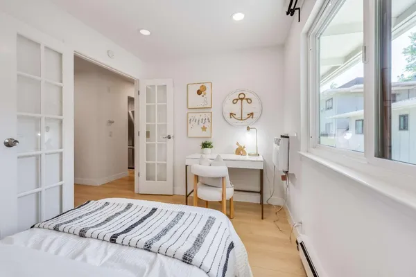 a bedroom with a bed and a table in it with wooden floor