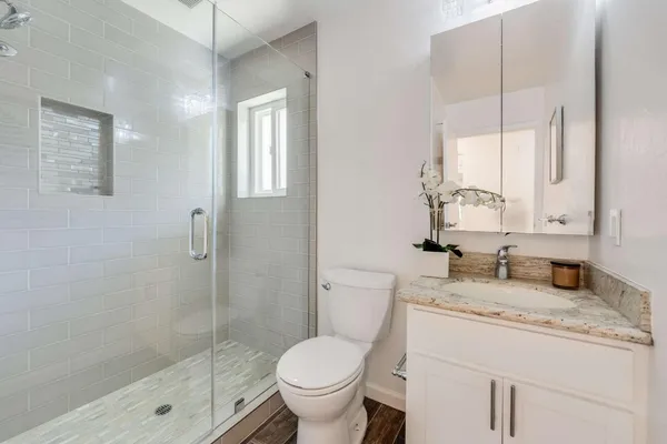 a bathroom with a granite countertop sink toilet and shower