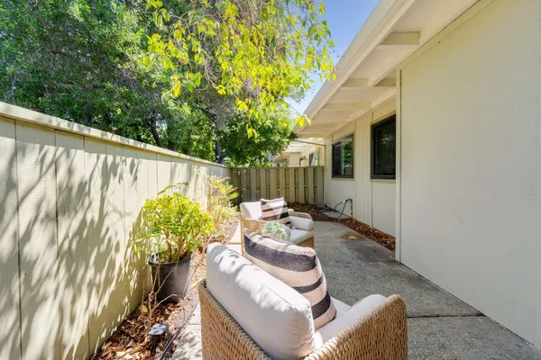 a view of a patio with table and chairs with wooden fence and plants