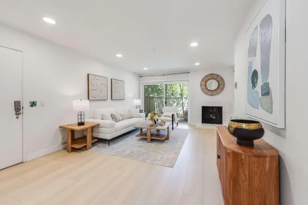 a living room with furniture a fireplace and a window