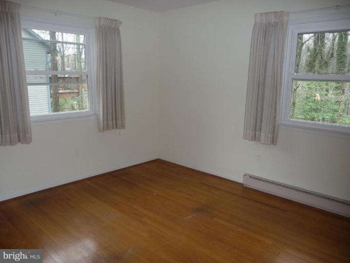 3074 Tudor Hall Road Riva, MD 21140 - Photo 7 of 13 a view of an empty room with wooden floor and a window
