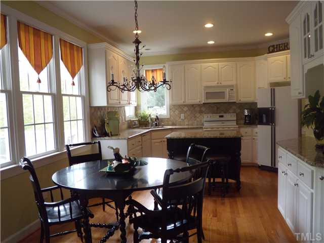 3809 La Costa Way Raleigh, NC 27610 - Photo 5 of 25 a kitchen with stainless steel appliances granite countertop a stove a refrigerator a kitchen island a table and chairs