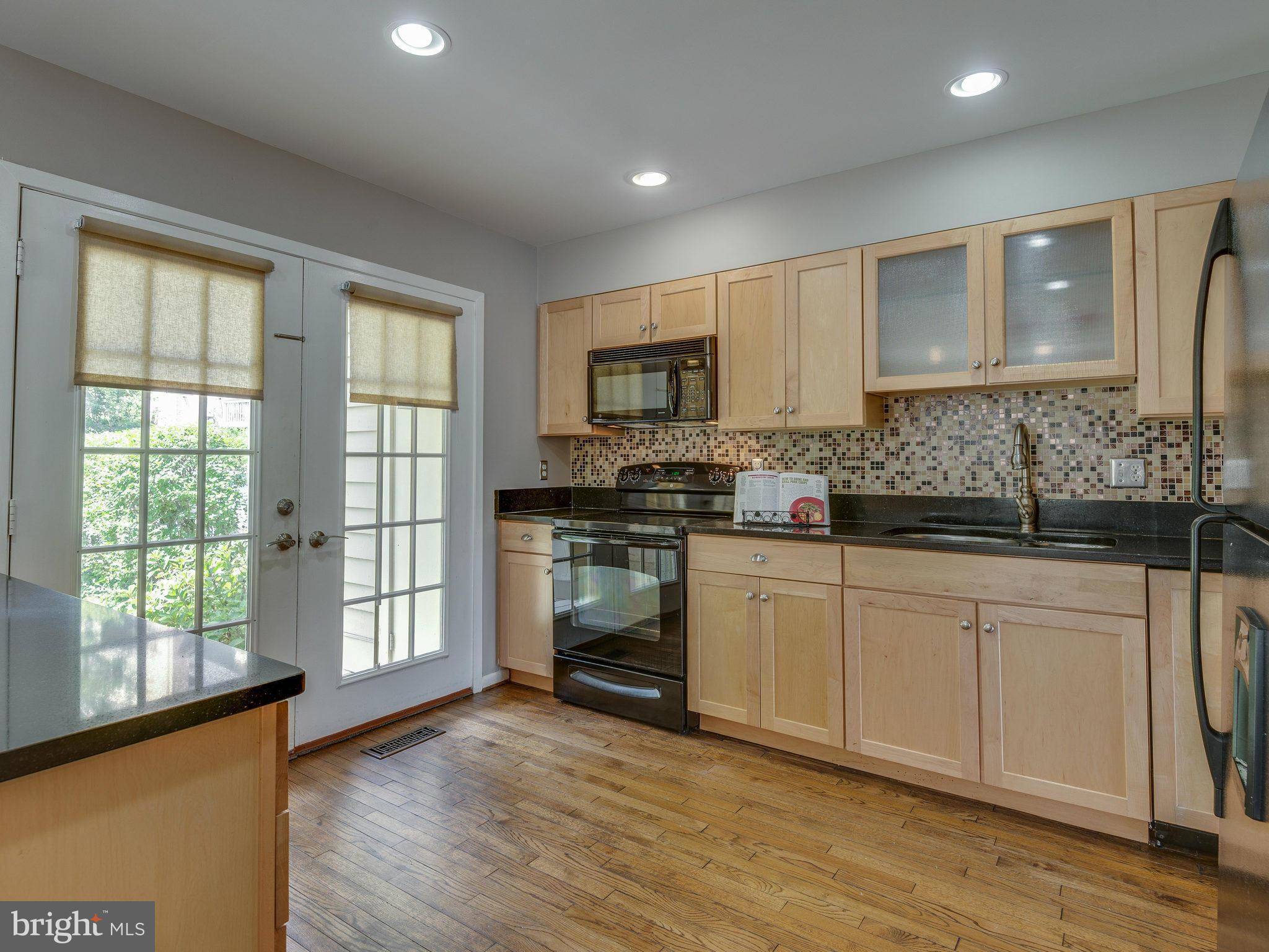 11131 Lake Chapel Lane Reston, VA 20191 - Photo 5 of 30 a kitchen with stainless steel appliances granite countertop a stove a sink and white cabinets