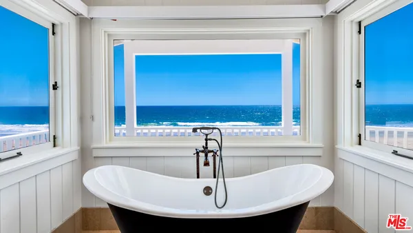 a bedroom with a bed and a large mirror on the wall