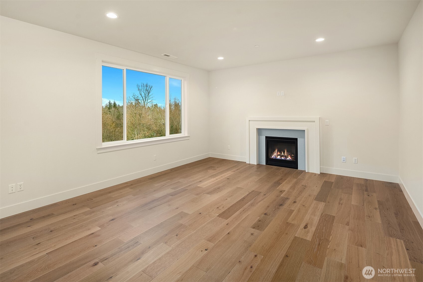 8409 Northeast 156th Street Kenmore, WA 98028 - Photo 6 of 16 an empty room with wooden floor and a fireplace