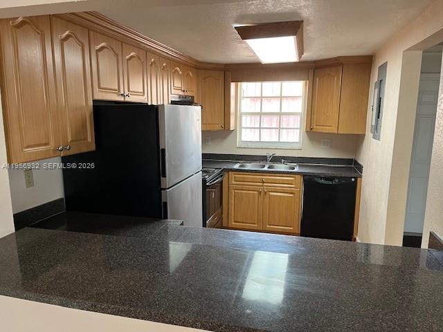 4250 West 11th Lane, Unit 43 Hialeah, FL 33012 - Photo 20 of 31 a kitchen with granite countertop wooden cabinets and a refrigerator