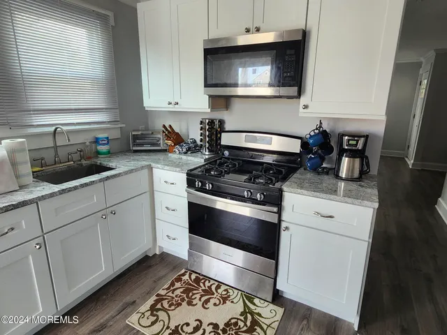 a kitchen with white cabinets and appliances