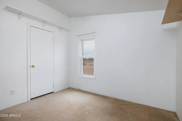 an empty room with a window and a fan