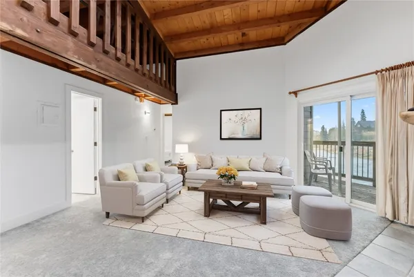 a living room with furniture and a floor to ceiling window