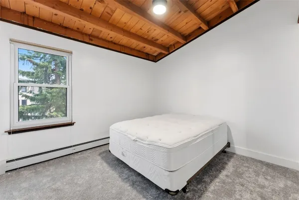 a bed sitting in a bedroom next to a window